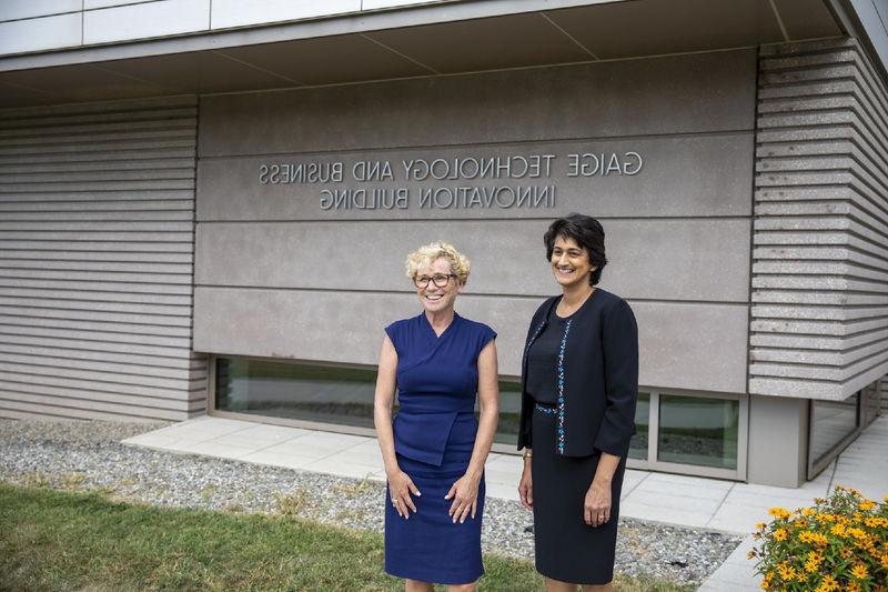 Chancellor Pyati and Rep. Houlahan pose in front of the Gaige Technology and Business Innovation Building sign